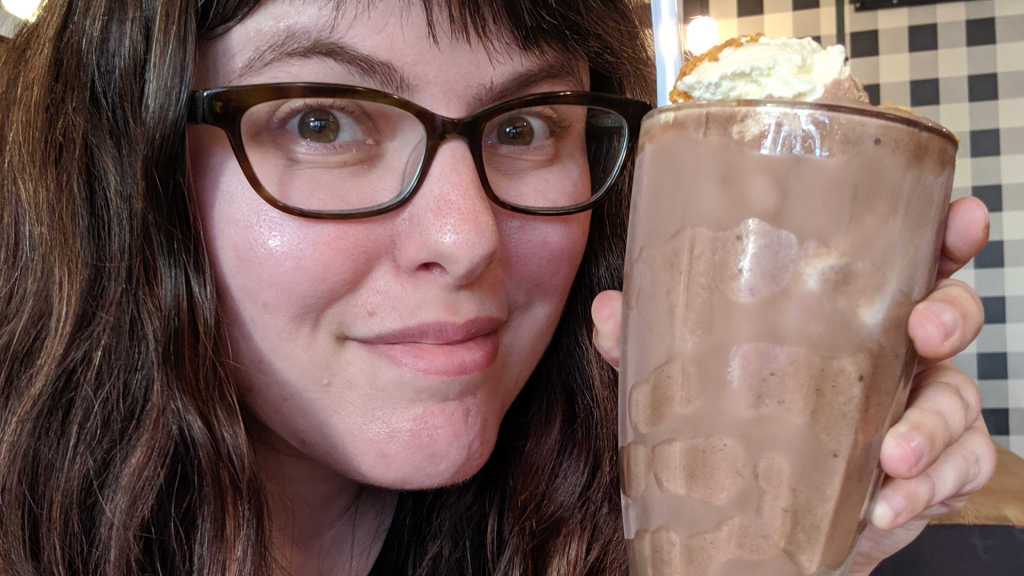 Jess holding a chocolate shake at Hot Cakes.